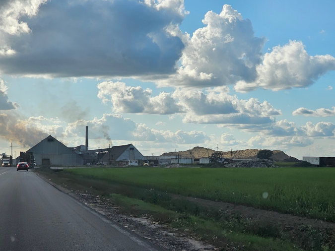 Mountains of bagasse lie behind a sugar mill