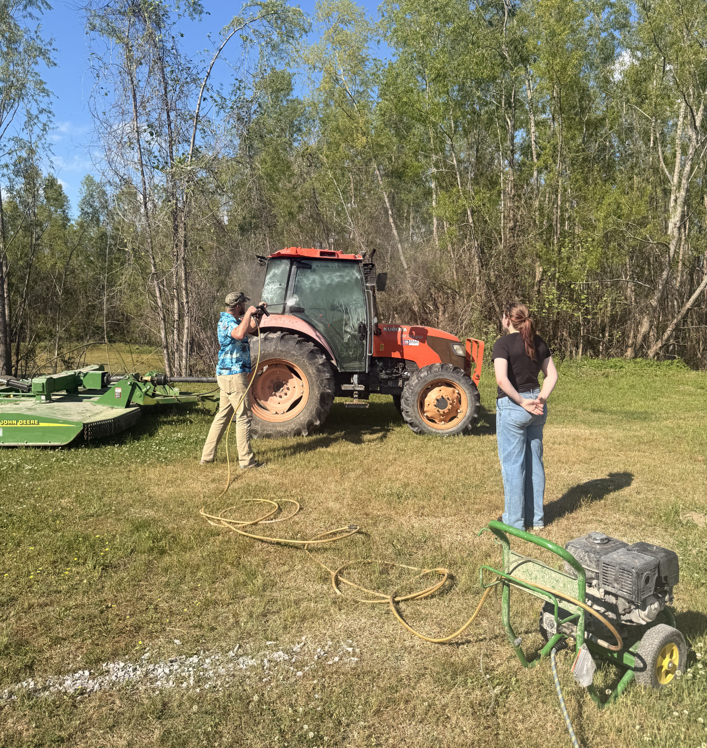 Student assists with pressure washing equipment