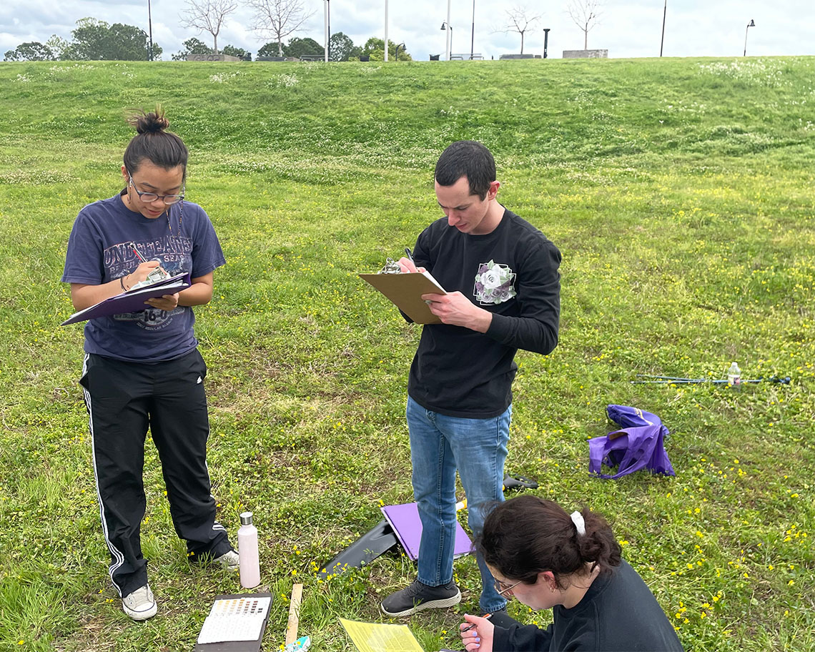 students in the field with notebooks