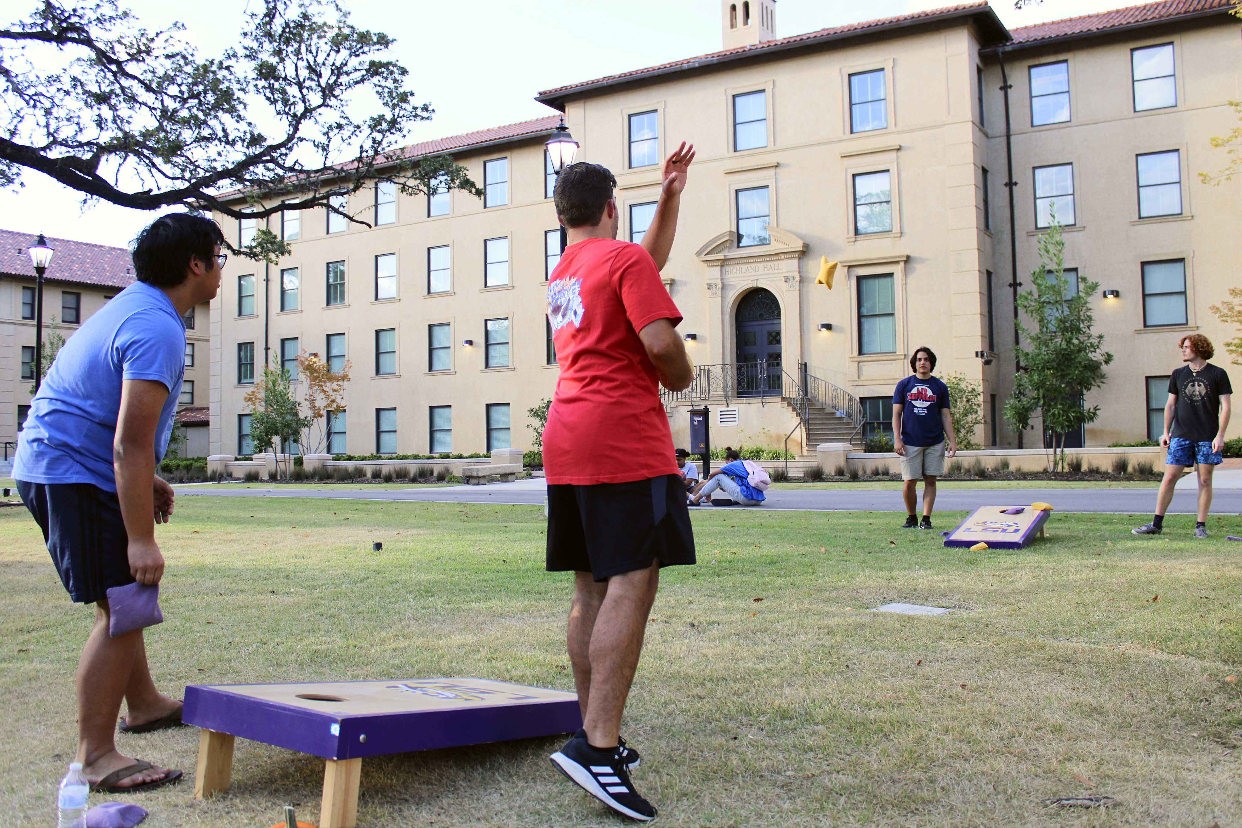 Students playing cornhole infront of Highland Hall.